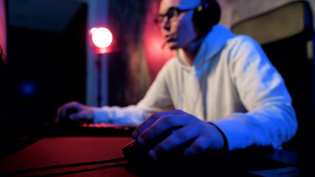 Close-up-addiction-guy-with-manly-hands-playing-video-game-on-computer-screen-with-fingers-on-keyboard.-Selective-focus-on-a-hand-with-mouse