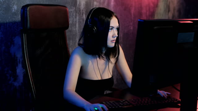 Ernst-Frau-gamer-spielen-online-Spiel-auf-einem-pc-Computer-tragen-Kopfhörer-und-sprechen-mit-einem-Team-mit-Mikrofon
