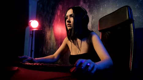 Frau-startet-Online-Spiel-mit-ihren-Freunden.-Gamer-Mädchen-Online-Spiel-auf-einem-pc-Computer-tragen-Kopfhörer-und-sprechen-mit-einem-Team-mit-Mikrofon