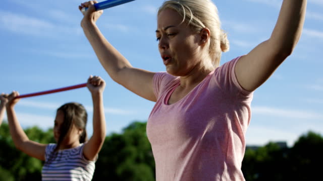 Woman-with-kids-exercising-on-sports-ground