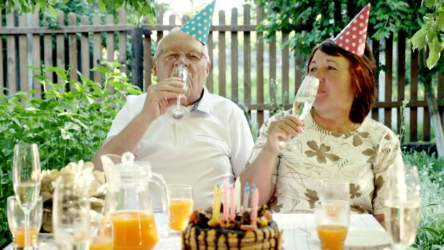 Loving-senior-couple-celebrating-anniversary-with-cake