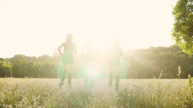 Tres-chicas-en-botas-con-resortes-corriendo-por-el-parque-de-verano-al-atardecer-haciendo-deportes
