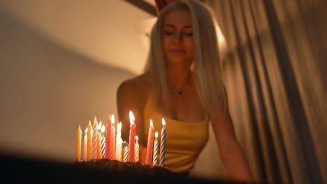 Sexy-rubia-caliente-ver-velas-de-iluminación-del-hombre-sobre-el-pastel-de-cumpleaños