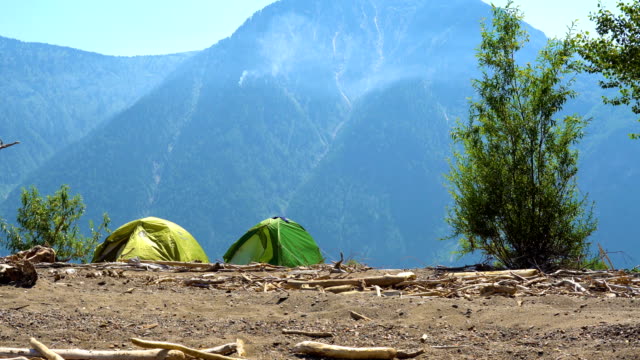 Two-tents-on-the-sandy-shore-of-the-lake-in-the-mountains.