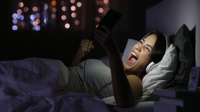 Aufgeregt-Teen-lesen-gute-Nachrichten-in-einem-Telefon-in-der-Nacht