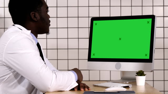 Afrikanischen-Arzt-video-Anruf-mit-seinem-Computer.-Weißes-Display