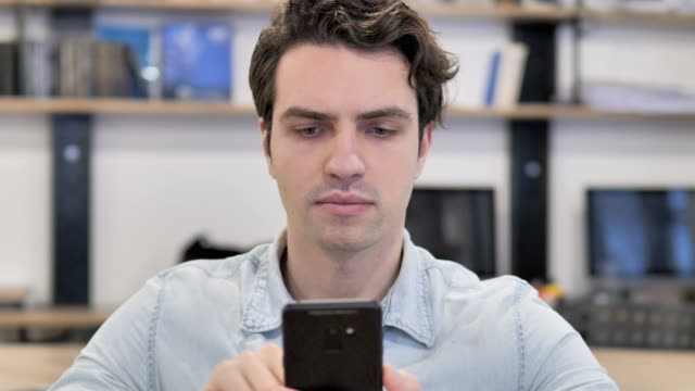 Portrait-of-Creative-Man-Using-Smartphone-in-Office