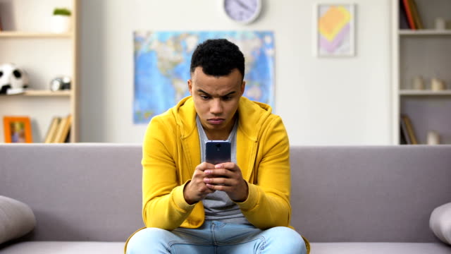 Afroamerikanischer-Teenager,-der-virales-Spiel-auf-dem-Smartphone-spielt,-Gadget-Sucht