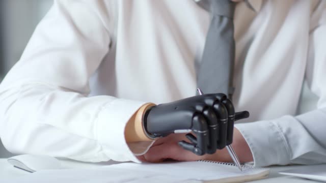 Businessman-Writing-Note-with-Prosthetic-Hand