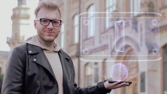 Kluger-junger-Mann-zeigt-Hologramm-Smartphone-Doppelkamera