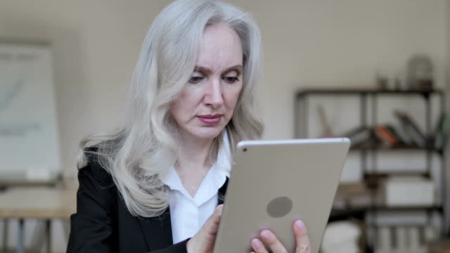 Vieja-mujer-de-negocios-usando-la-tableta