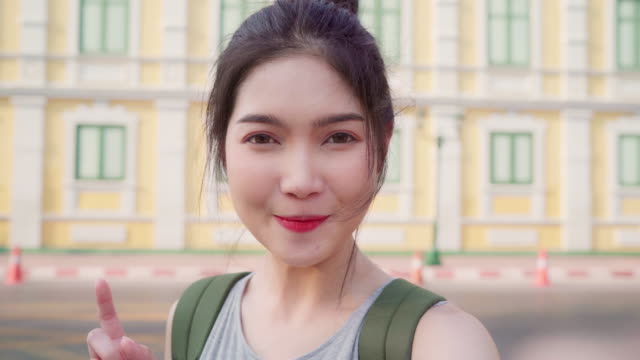 Asian-blogger-woman-travel-in-Bangkok,-Thailand,-backpacker-female-using-mobile-phone-make-vlog-and-live-in-social-media-while-spending-sweet-time-in-holiday-trip.-Women-travel-in-city-concept.