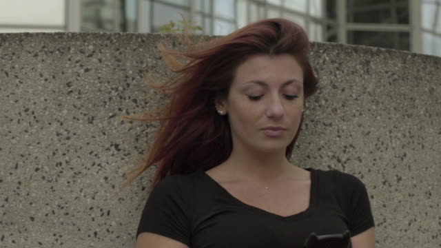 Traurige-Frau-mit-Smartphone-Sitzen-im-Geschäftsviertel,-besorgt-beim-SMS-mit-Handy-draußen,-Eingabe-von-SMS-auf-Handy.-Paris,-rote-Haare.-soziale-medien.-Slow-Motion-aus-nächster-Nähe.