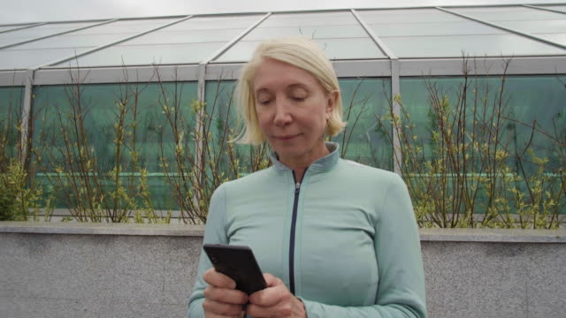 Kaukasische-Frau-mittleren-Alters-mit-Smartphone