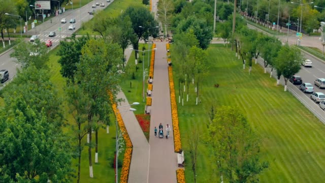 Family-with-a-disabled-son-goes-through-the-park.-Aerial-view-video-from-copter.-Top-view.