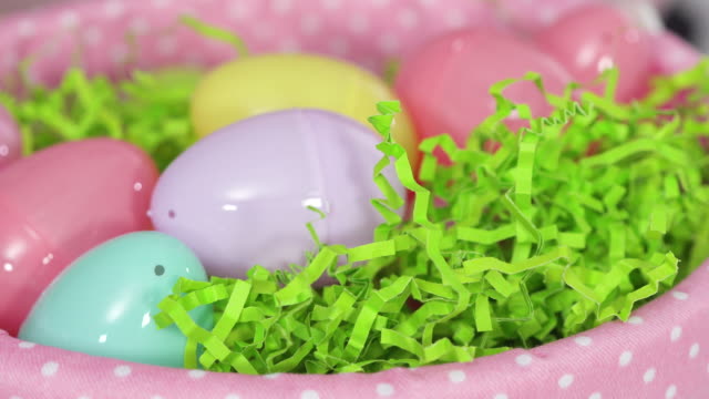 Cierre-de-la-cesta-de-Pascua-con-huevos-de-plástico-sobre-un-fondo-rosa.