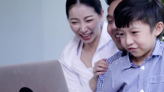 Familie-mit-Laptop-und-digitale-Tablet-Arbeit,-Eltern-lehren-ihren-Jungen-versuchen,-auf-Labtop-zu-lernen
