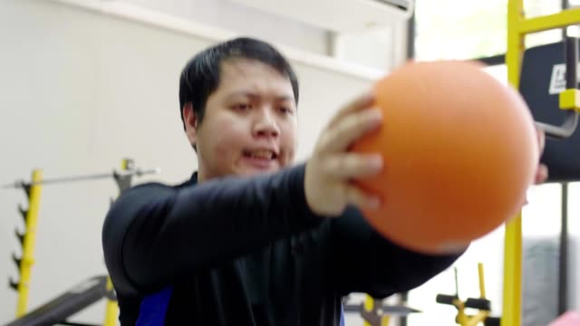 Hombre-asiático-tratando-de-hacer-ejercicio-con-mancuerna-en-el-gimnasio,-estilo-de-vida-saludable,-deseo-de-pérdida-de-peso