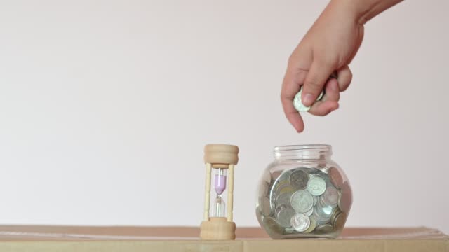 Geschäftsmann-steckt-eine-Münze-in-einem-Glasflaschen-Konzept,-Geld-zu-sparen-und-in-Finanzgeschäfte-zu-investieren.-Video-4K