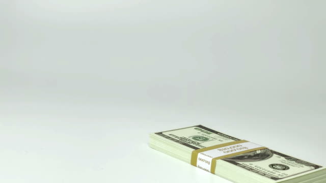 Investing-funds,-economics-transaction-and-wealthy-millionaire-counting-money-conceptual-idea-with-hand-that-stacks-wads-of-100-American-dollar-bills-isolated-on-white-background-with-copy-space