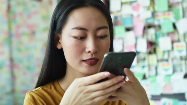 Vista-de-mano-de-la-mujer-vietnamita-con-teléfono-celular-en-el-café