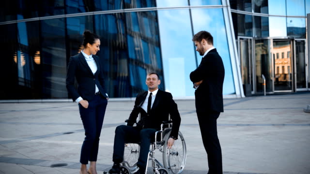 Krüppel-Geschäftsmann-im-Rollstuhl-und-zwei-seiner-Kollegen-hat-positive-Gespräch