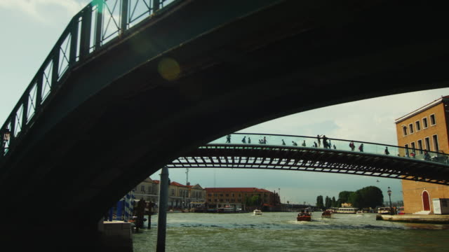 Beautiful-bridges-of-Venice.-Swim-under-the-bridge,-the-sun-shines-beautifully-with-glare.-Great-vacation-in-Venice