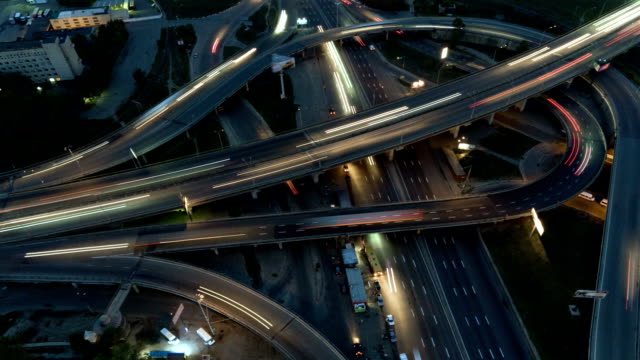Vertical-top-down-aerial-view-of-traffic-on-freeway-interchange-at-night.