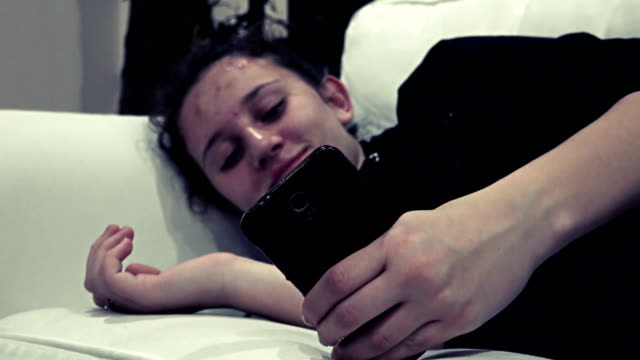 Smartphone-girl-using-app-on-phone-lying-at-hotel-lobby-sofa