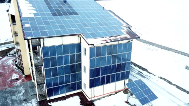 Hotel-complex-in-the-mountains-with-solar-panels-on-the-snow.