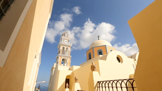 Beautiful-church-with-clock-bell-tower-in-village-Fira-on-Santorini,-tourism