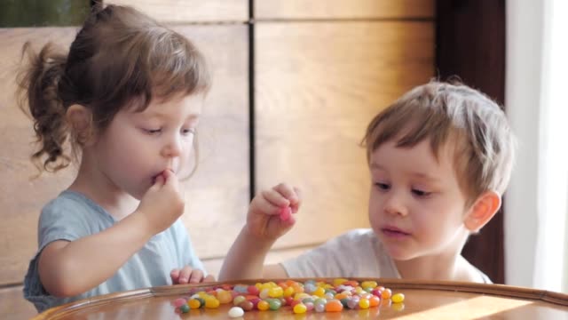 niños-lindos-comiendo-caramelos-coloridos