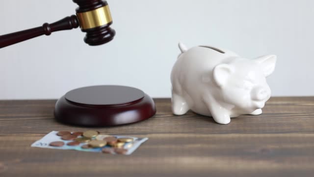 Money-and-justice-concept,-whacking--judge-hammer.-Euro-coins-and-piggy-bank-on-the-desk