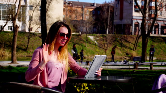 Gladden-Mädchen-machen-video-telefonisch-Tablet-Freund-im-Park-und-winkenden-hand
