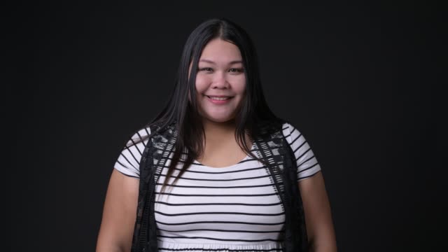 Beautiful-overweight-Asian-woman-against-black-background