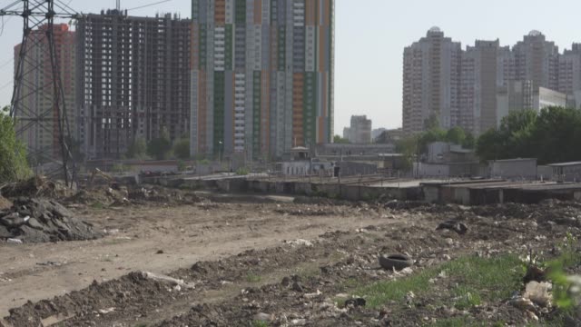Outskirts.-Polluted-soil-with-various-debris-near-the-metropolis-with-high-rise-buildings.-Environmental-pollution