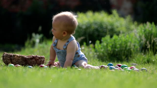 Niño-lindo,-jugando-con-little-bunny-y-Pascua-huevos-en-una-primavera-floreciente-jardín.-Niño-juega-con-el-conejo,-caza-para-vacaciones-del-huevo