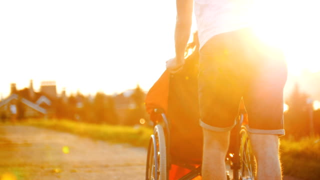 Guy-Rolls-Girl-In-A-Wheelchair-On-A-Summer-Evening-In-The-Sunset