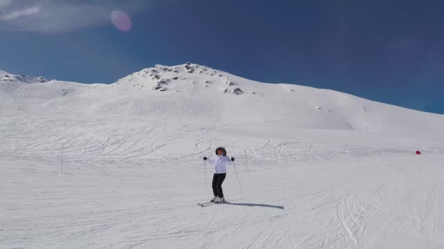 Esquiador-esquí-abajo-de-la-ladera-de-la-montaña-y-levanta-sus-manos-hasta-retratar-éxito