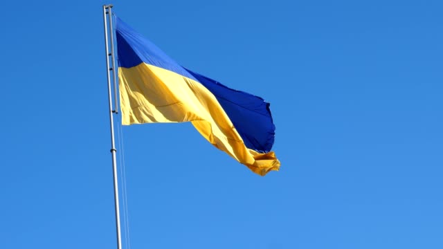 Ucraniana-bandera-ondeando-en-el-viento-y-el-azul-cielo.