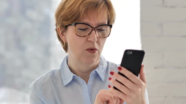 Alte-Frau-unter-Schock-während-mittels-Smartphone