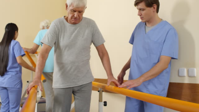 Gente-mayor-entrenamiento-del-paso-con-ayuda-de-fisioterapeutas