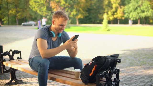 kaukasischen-Kerl-Messaging-Text-auf-dem-Handy-beim-open-air