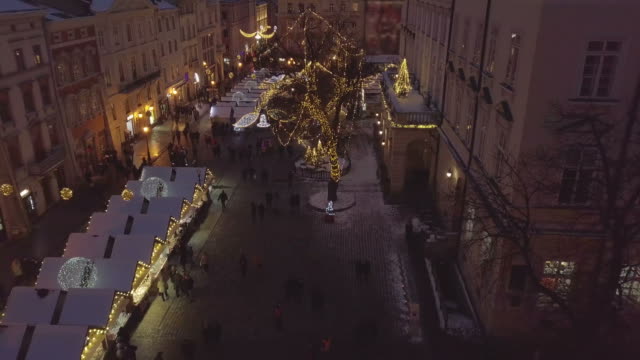 Lviv,-Ucrania---25-de-diciembre-de-2018.-Tiro-de-Arial.-Invierno.-Calle-plaza-Rynok.-Feria-de-Navidad.-Ayuntamiento-de-Lvov,-Consejo-de-la-ciudad.-Personas-están-caminando-en-el-centro-de-la-ciudad.-Adornos-navideños-y-luces.-Noche