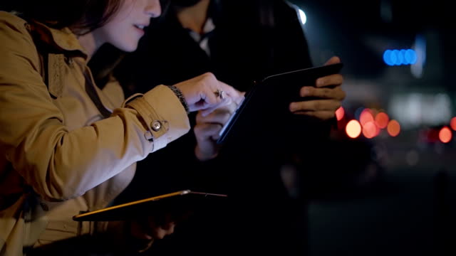 Par-utilizar-tablet-pc-juntos-en-la-ciudad-de-noche