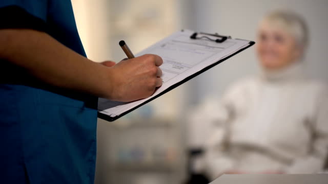 Médico-tomando-notas-en-registros-médicos-y-el-examen-de-anciana,-hospital