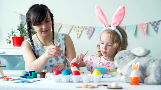 Woman-and-Girl-Coloring-Easter-Egg-with-Red-Color