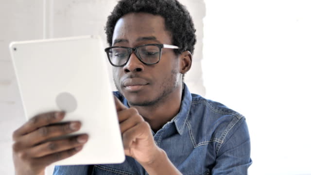 Creative-African-Man-Browsing-Internet-on-Tablet