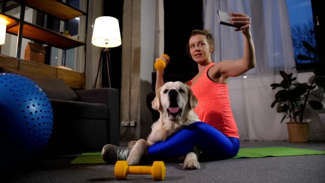 Smiling-fit-female-posing-for-selfie-shot-with-dog
