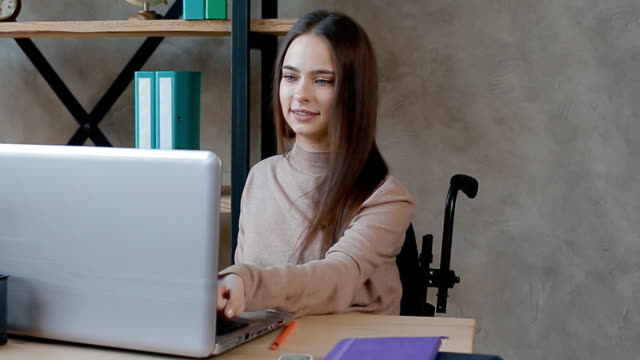 Behinderte-junge-Frau-arbeitet-mit-Laptop-im-Büro